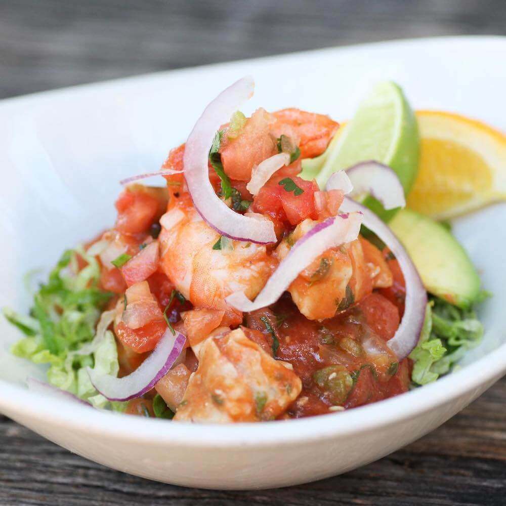 Campechana — Gulf shrimp in zesty tomato salsa with red onion, avocado and lime on shredded lettuce