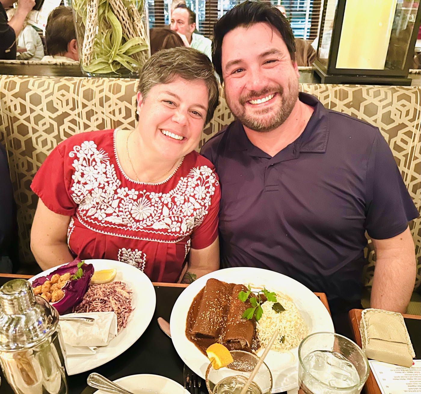 A couple celebrating over mole enchiladas in a banquette at Manuel's